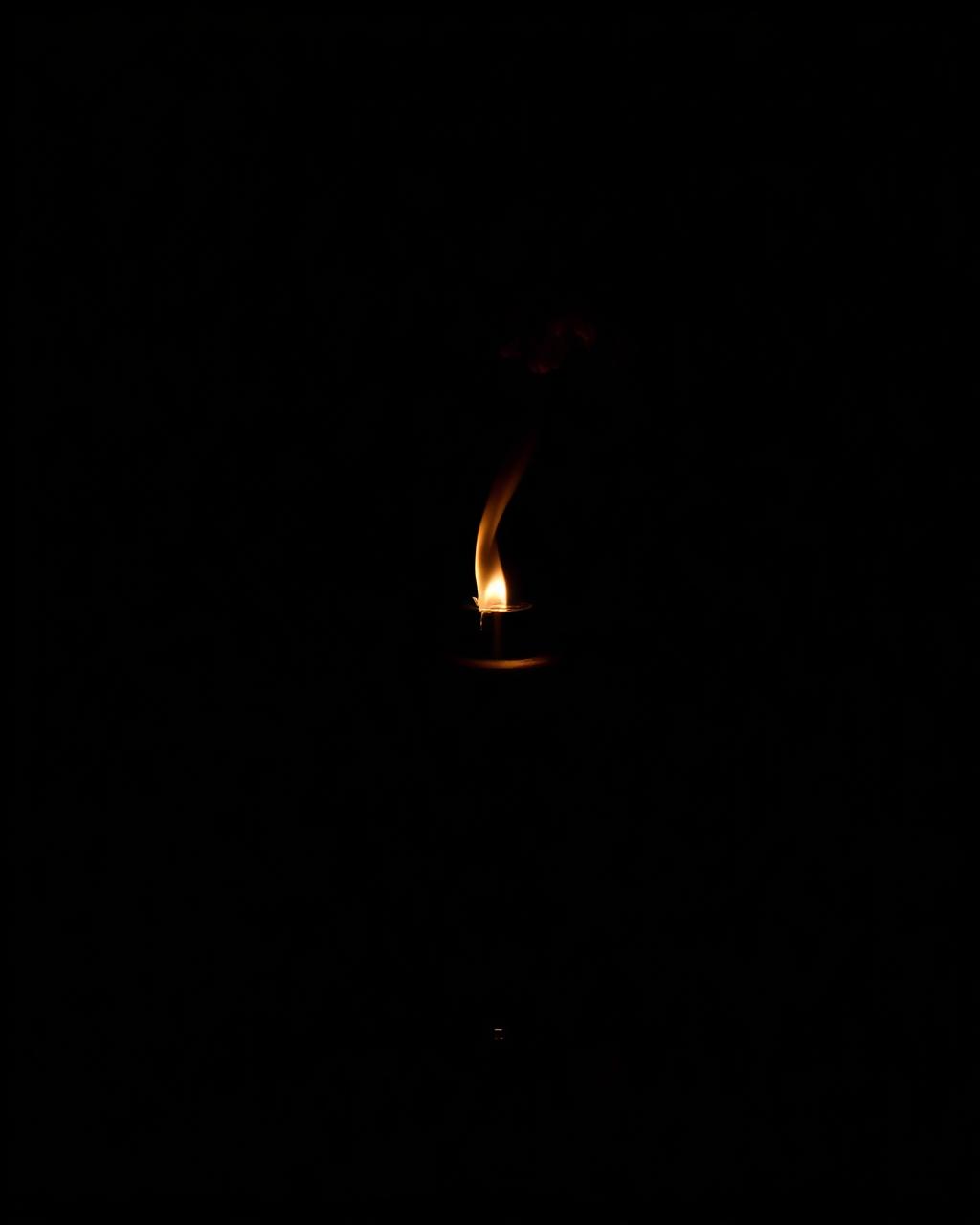 Vespro — dark bottle in candlelit shadow with a thread of smoke.
